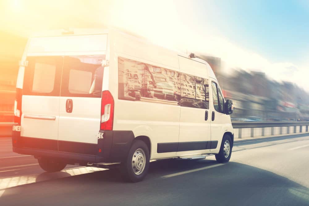 A small shuttle bus against a blurred background 